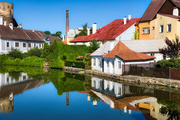 Obraz premium Houses Reflecting in the Vajgar Pond in the Hamersky Potok River at Jindrichuv Hradec in the Czech Republic