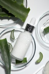 Flat lay composition with cosmetic products and cut aloe vera on white background