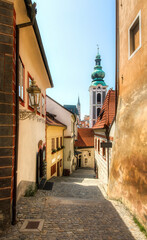 Cobbled Alley in the Beautiful Old City of Cesky Krumlov in the Czech Republic, with the Tower of St Jost Church - obrazy, fototapety, plakaty