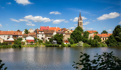 Houses in Beautiful Telc by the Lake Ulicky Rybnik in the Czech Republic, with the Tower of the Church of the Holy Spirit