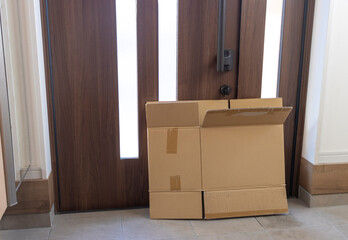 潰した使用済みダンボールと玄関 ドア