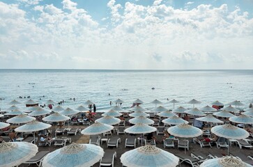 View on sea resort in cloudy weather, sky, sunbeds and parasols, landscape