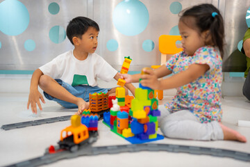 Adorable little child boy and girl playing plastic block toy building imagination - obrazy, fototapety, plakaty