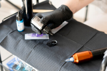 a tattoo studio table with machine, needle and bottles with ink