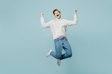 Fototapeta na wymiar Full body happy fun young ill sick man wear gray sweater jump high do winner gesture isolated on plain blue background studio. Healthy lifestyle disease virus treatment cold season recovery concept.