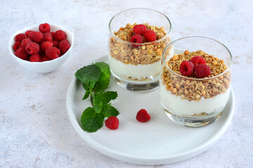 healthy snack with yogurt, oatmeal and raspberry in drinking glass   