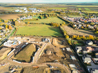 Aerial view of a large housing development site in East Anglia for both private and affordable homes. Various stages of house construction is seen.