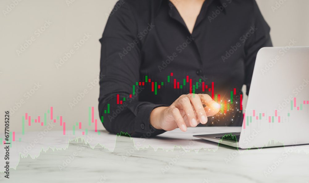 Aufkleber businesswoman or trader pointing to a graph stock on a virtual screen while sitting at the table.