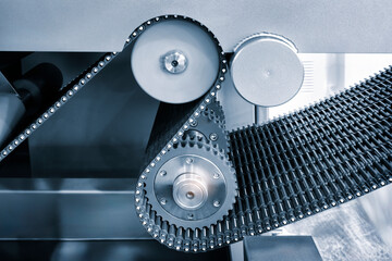 Gear chain drive shaft in conveyor belt is on production line. Timing chain of car, tensioners in engine. Industrial roller chain, technology. Team work, business industrial concept