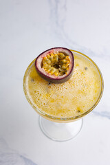 Alcoholic cocktail with cut passion fruit at the bar 