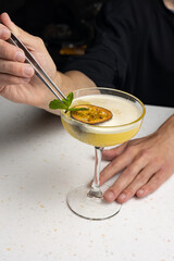 Alcoholic cocktail with cut passion fruit at the bar 