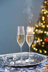 Glasses with champagne near Christmas tree
