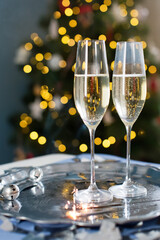 Glasses with champagne near Christmas tree