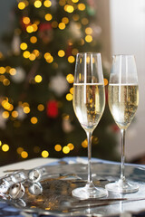 Glasses with champagne near Christmas tree