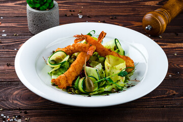Hot tempura shrimp fried breaded with a salad of cucumbers, lettuce, capers, apples and pumpkin seeds.