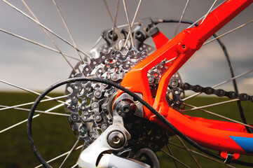 Close-up of mountain bike sprockets and chain. Bicycle parts, fragment of rear wheel brake disc, frame