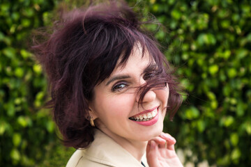 A woman's hair was blown across her face by the wind, close-up portrait.