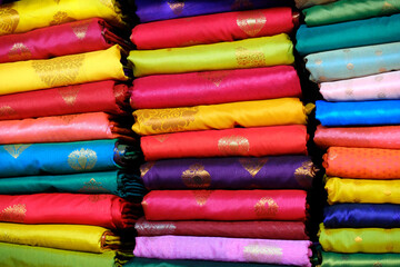 Fancy Indian sarees, Neatly stacked colorful silk saris in racks in a textile shop. Incredible India.