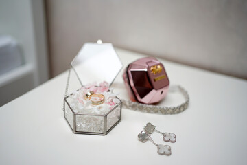 Two gold wedding rings in a glass box and wedding finery. Preparation for the wedding ceremony.