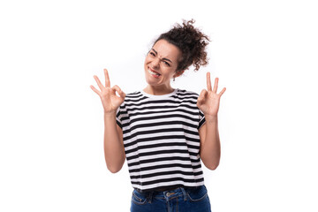 young caucasian woman with curly black hair dressed in a striped black and white t-shirt looks happy. people lifestyle concept