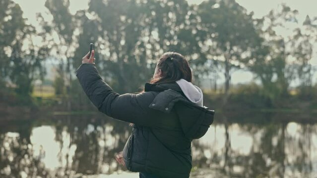 Hiking, phone and a woman lost in nature, searching for signal, directions or navigation in the forest. Mobile app, map or location with a young female hiker looking for a network connection