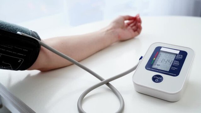 the girl measures blood pressure with a tonometer