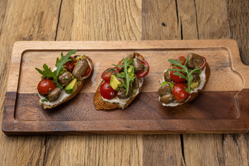 Tasty bruschetta with jamon and cheese on a wooden table