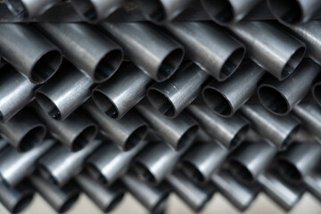 Stack of steel pipes. Close - up of stack of metal pipes. Industrial elements closeup. Parts stacked for further processing.