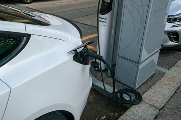 electric car charging, plug in to draw energy in the dedicated car park. Zero emissions in cities...
