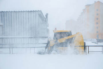 Snow blower tractor clearing snow from sidewalk during heavy snowstorm.