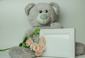 Gray bear toy with bouquet of roses