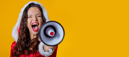 young woman wearing santa claus costume isolated shouting with megaphone