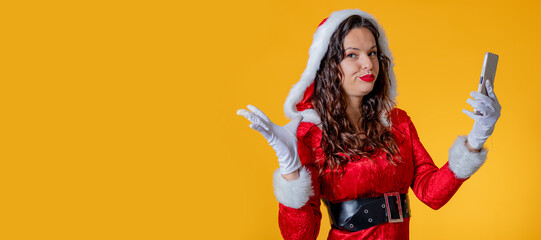 young woman in santa claus costume isolated using mobile phone or smartphone