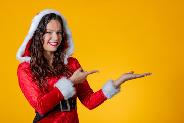 young woman wearing santa claus costume isolated pointing