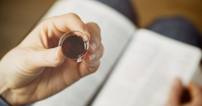 Woman taking communion - bread and wine. Christian faith and practice concept