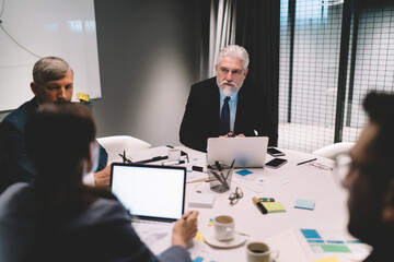 Group of coworkers sitting at table discussing project