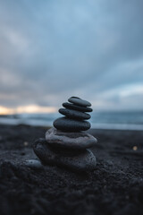 Fototapeta na wymiar stack of pebble at beach, stones pyramid at cloudy weather