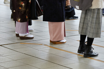 駅のホームで電車待ちの着物姿の女性たち