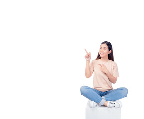 Full body young Asian woman pointing up to copy space and looking at blank space with smile face and happy Pretty girl sit on box chair use for advertising with isolated on white background