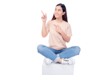 Full body young Asian woman pointing up to copy space and looking at blank space with smile face and happy Pretty girl sit on box chair use for advertising with isolated on white background