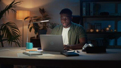 Man with laptop doing winner gesture during great news