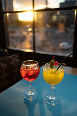 two color alcohol stylish cocktails in bar or restaurant, red and yellow