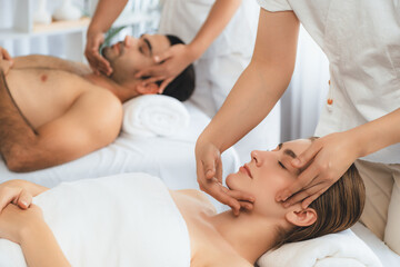 Obraz na płótnie Canvas Caucasian couple enjoying relaxing anti-stress head massage and pampering facial beauty skin recreation leisure in dayspa modern light ambient at luxury resort or hotel spa salon. Quiescent