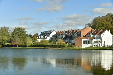 Fototapeta na wymiar Zone résidentiel se reflétant dans les eaux du Grand Etang à la Hulpe en Brabant Wallon 