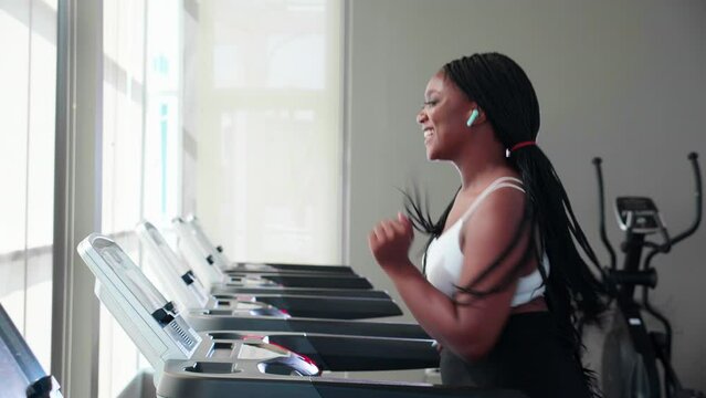 Young black woman workout with walking and exercise on machine treadmill in fitness gym sport club, woman cardio with training jogging, healthcare and motivation, female in sportswear and health.