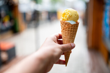 Close up of men hand holding delicious ice cream waffle cone outdoor