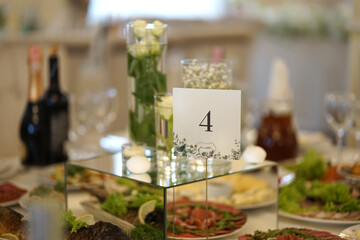 Four, which indicates the number of the festive table. Interior of the festive hall.