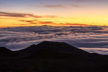 Sunrise view of mountain on Mauna Kea volcano sea of clouds in morning sun