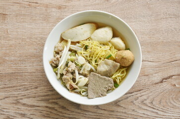 boiled Chinese yellow egg noodles with entrails and fish ball in soup on bowl