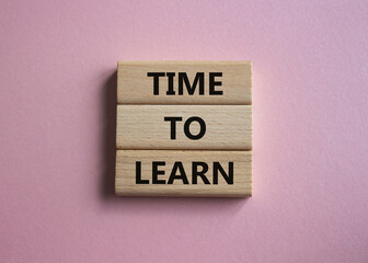 Time to learn symbol. Wooden blocks with words Time to learn. Beautiful pink background. Business and Time to learn concept. Copy space.